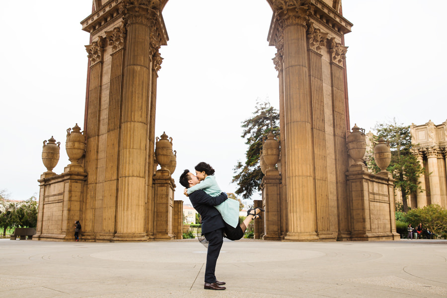 A man lifts his fiance up in the air