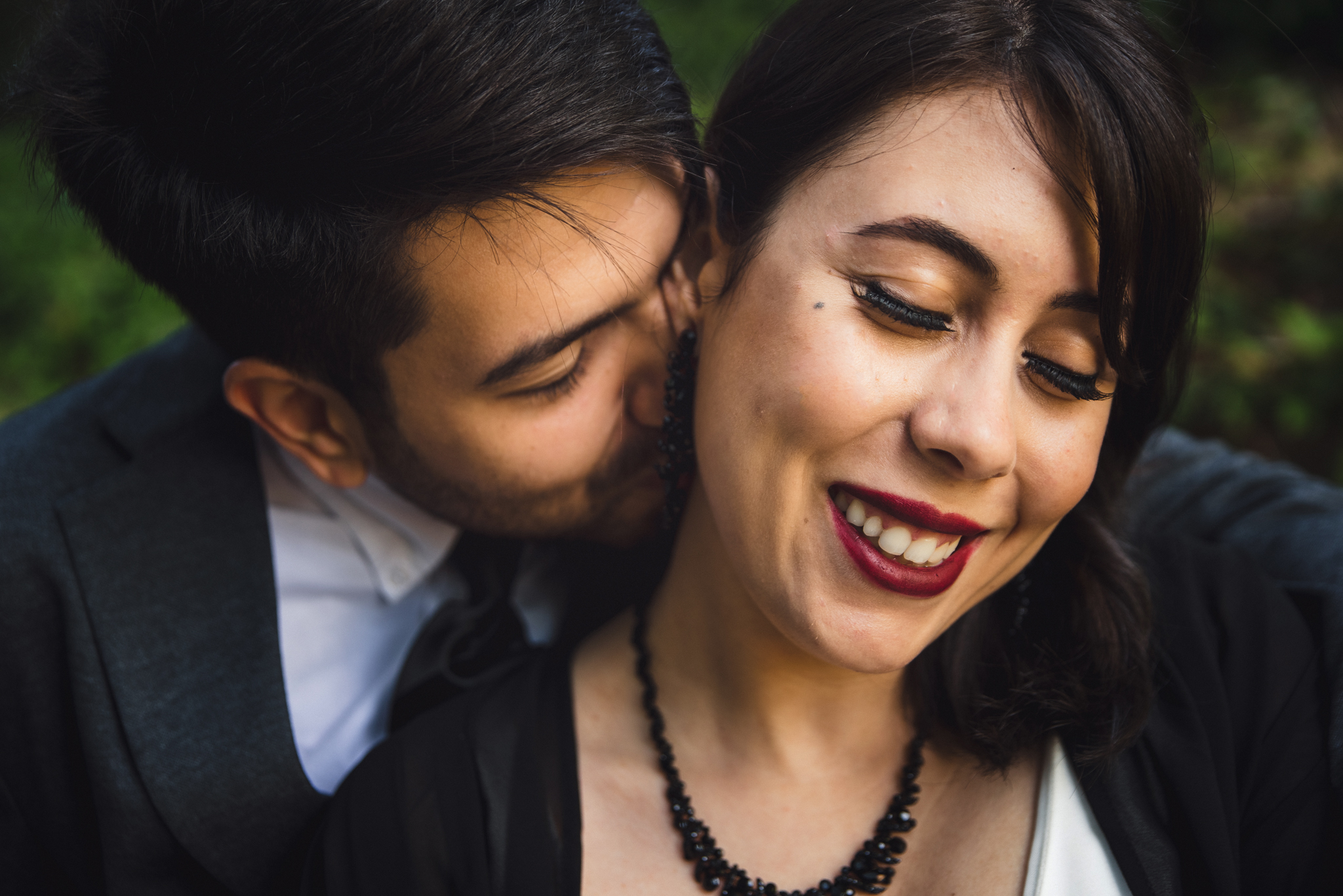 A groom kissed his new bride on the neck