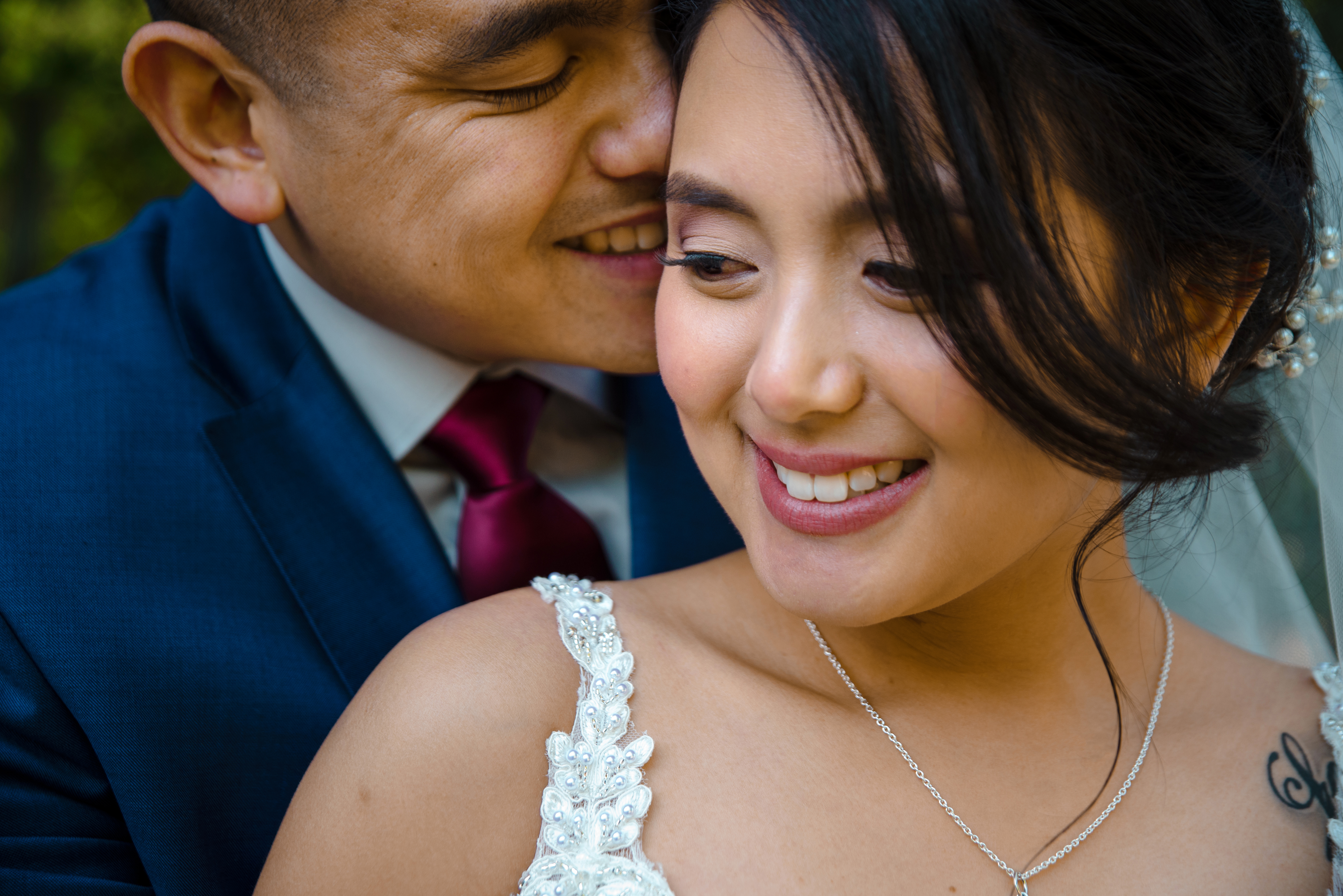 An image of a groom kissing his bride